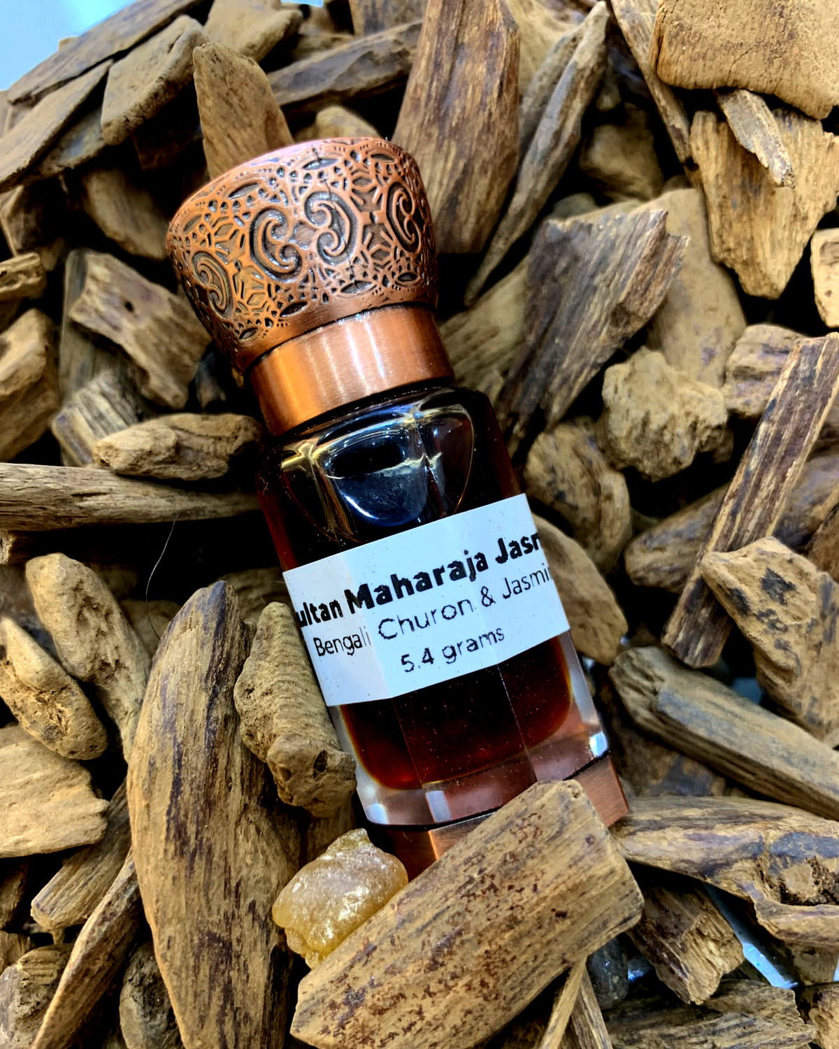 Sultan Maharaja Jasmine oud attar by IBN MA'IN resting on agarwood chips
